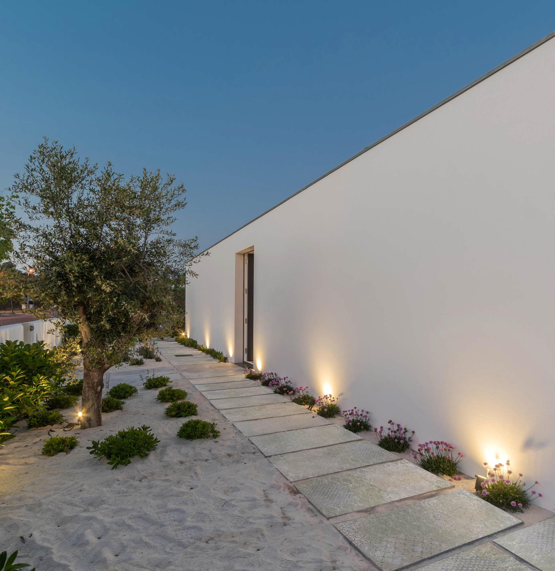 exterior with Aparici porcelain tiles with illuminated areas at night.